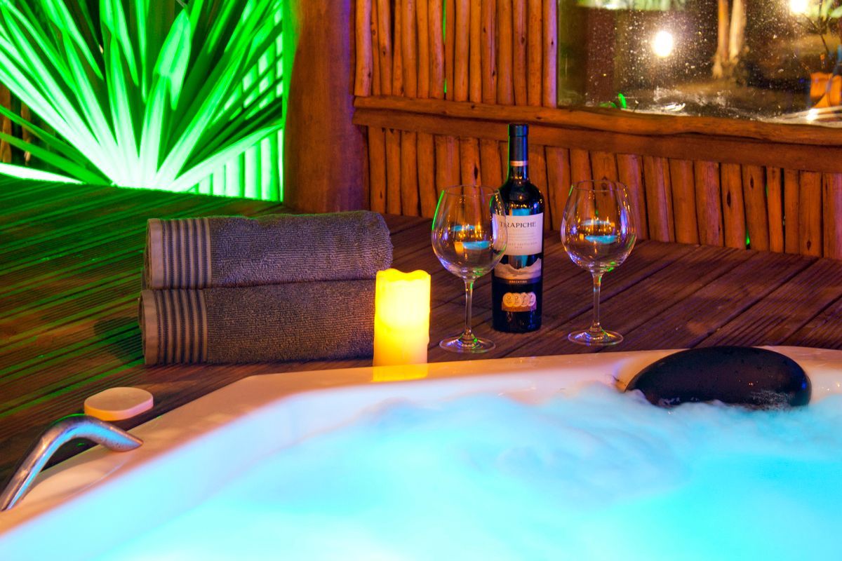 Há uma garrafa de vinho e duas taças de vinho na jacuzzi.