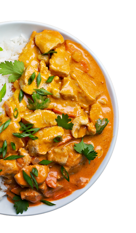 Chicken curry with white rice, garnished with cilantro and green onions, in a white bowl.