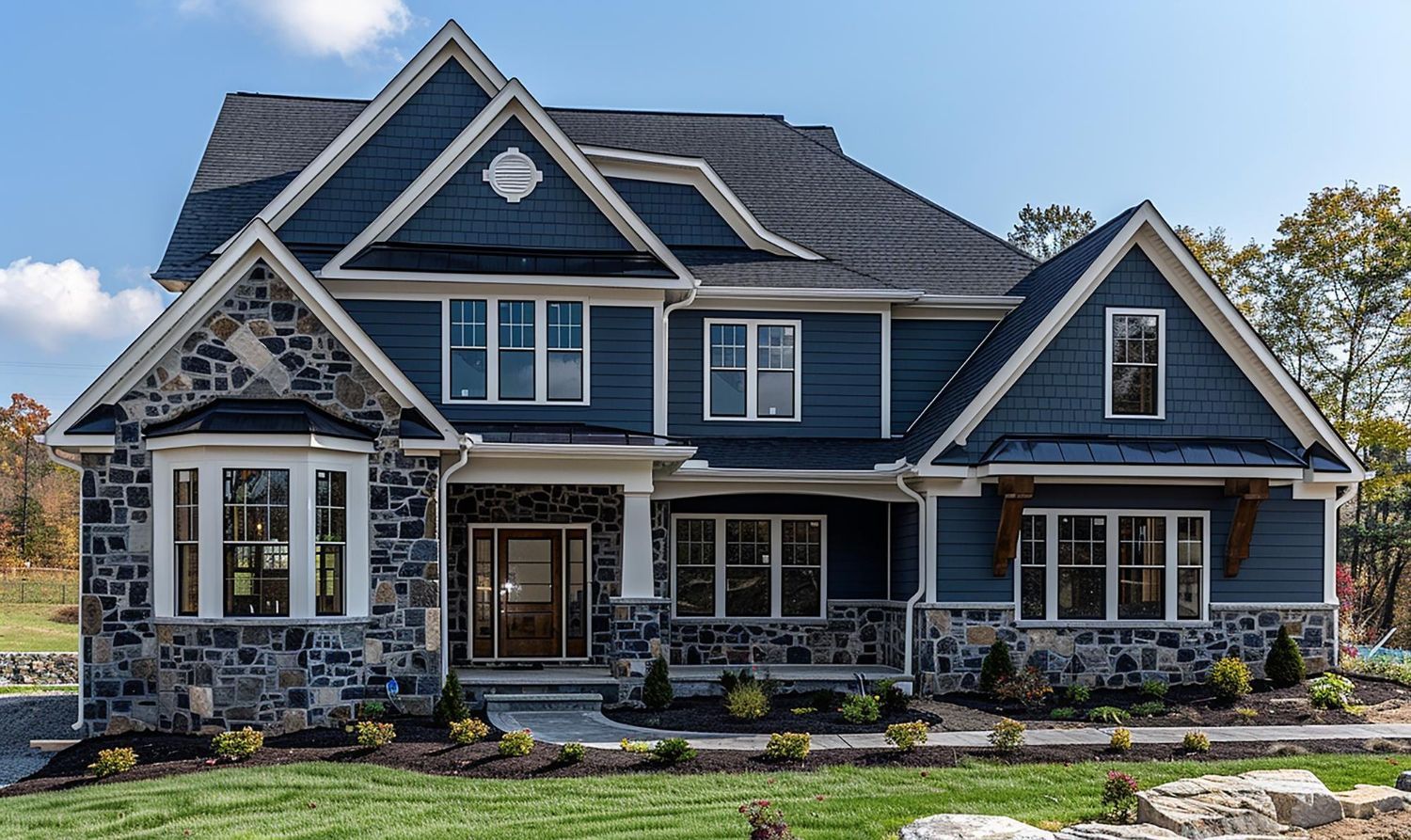 A large blue house with a lot of windows and a stone facade.