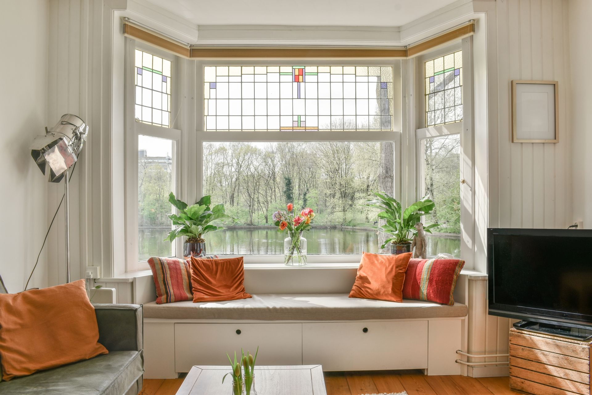 A living room with a bay window and a couch.