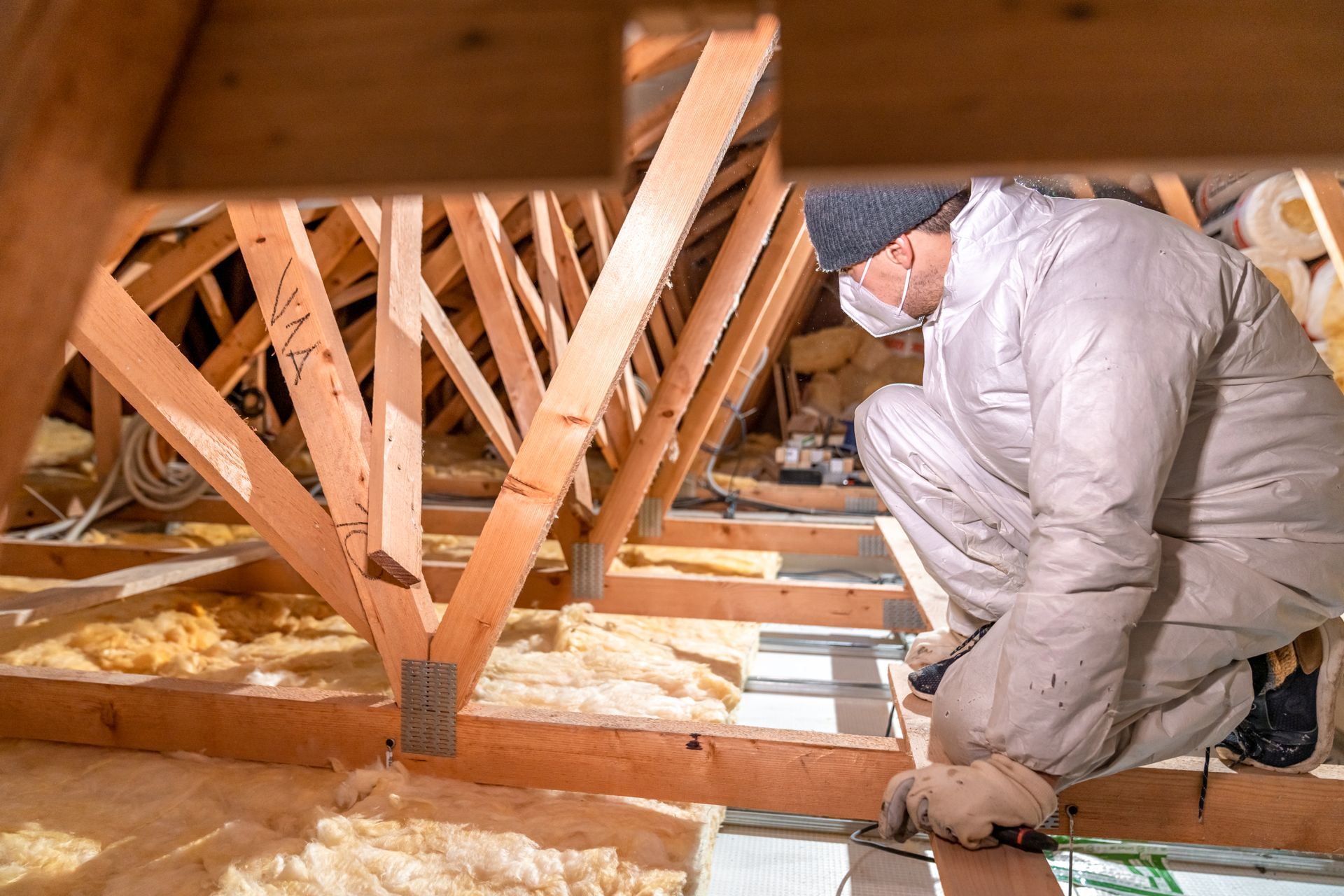 A man is working in the attic of a house.