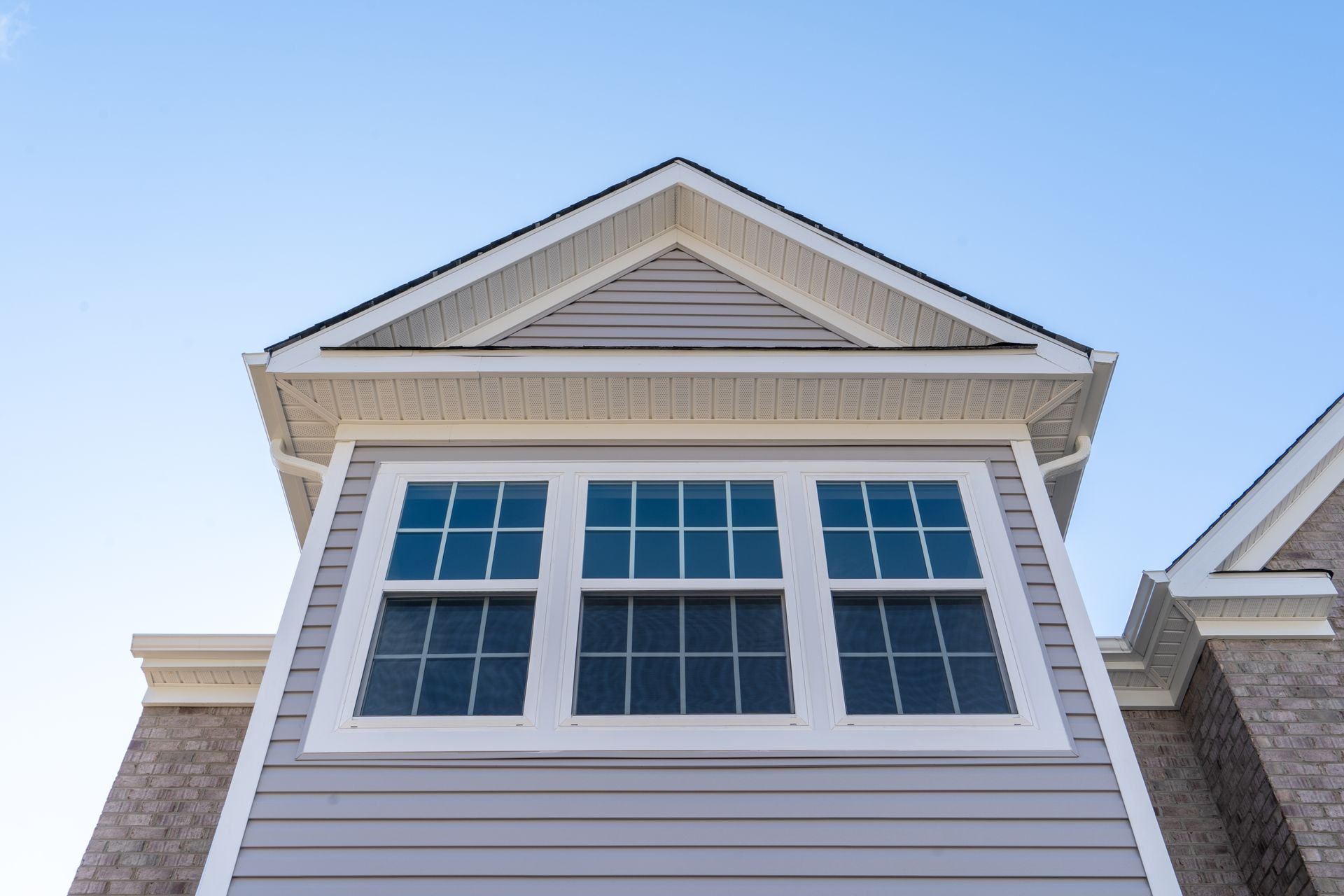 Looking up at the roof of a house with a blue sky in the background.