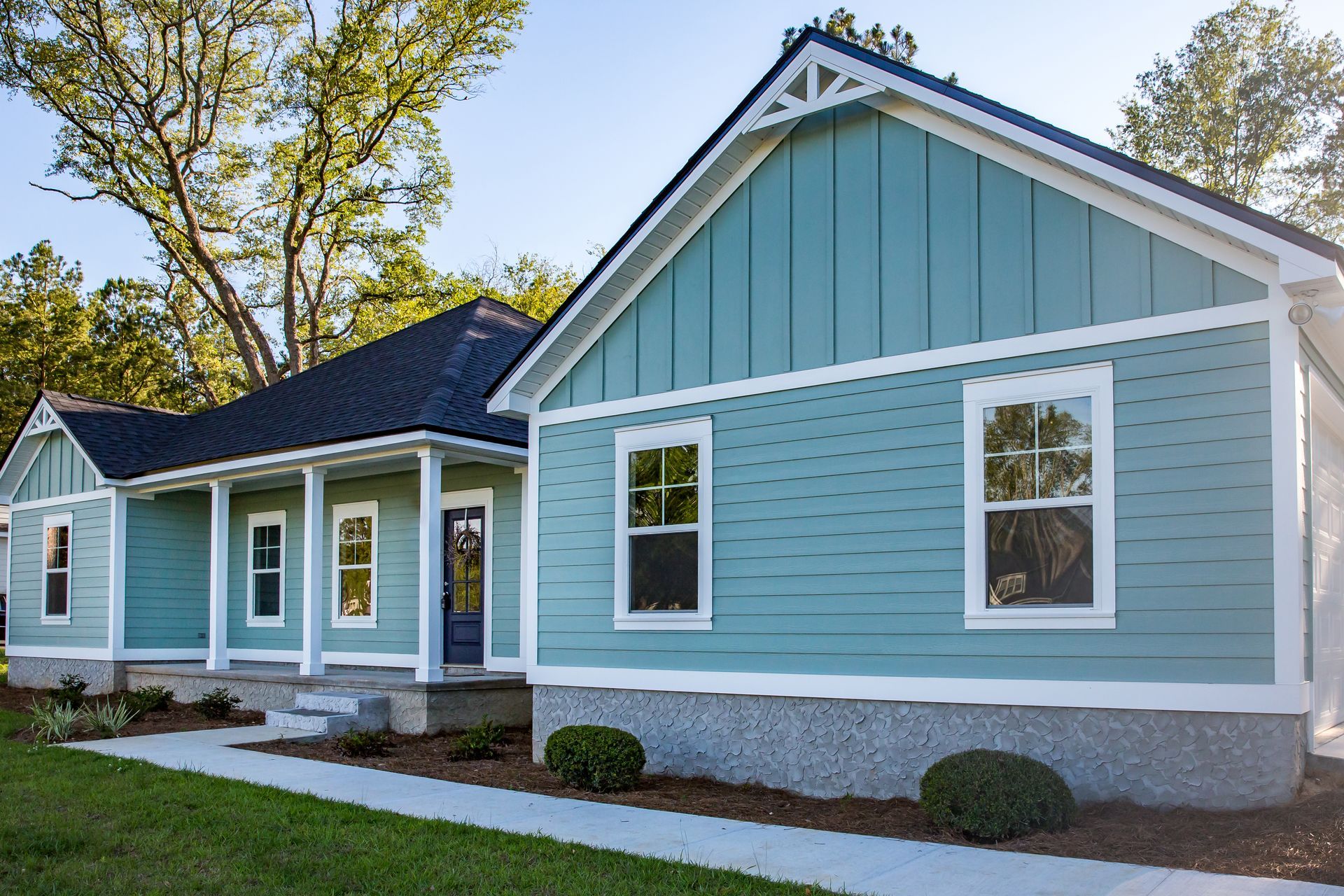 A blue house with white trim and a black roof