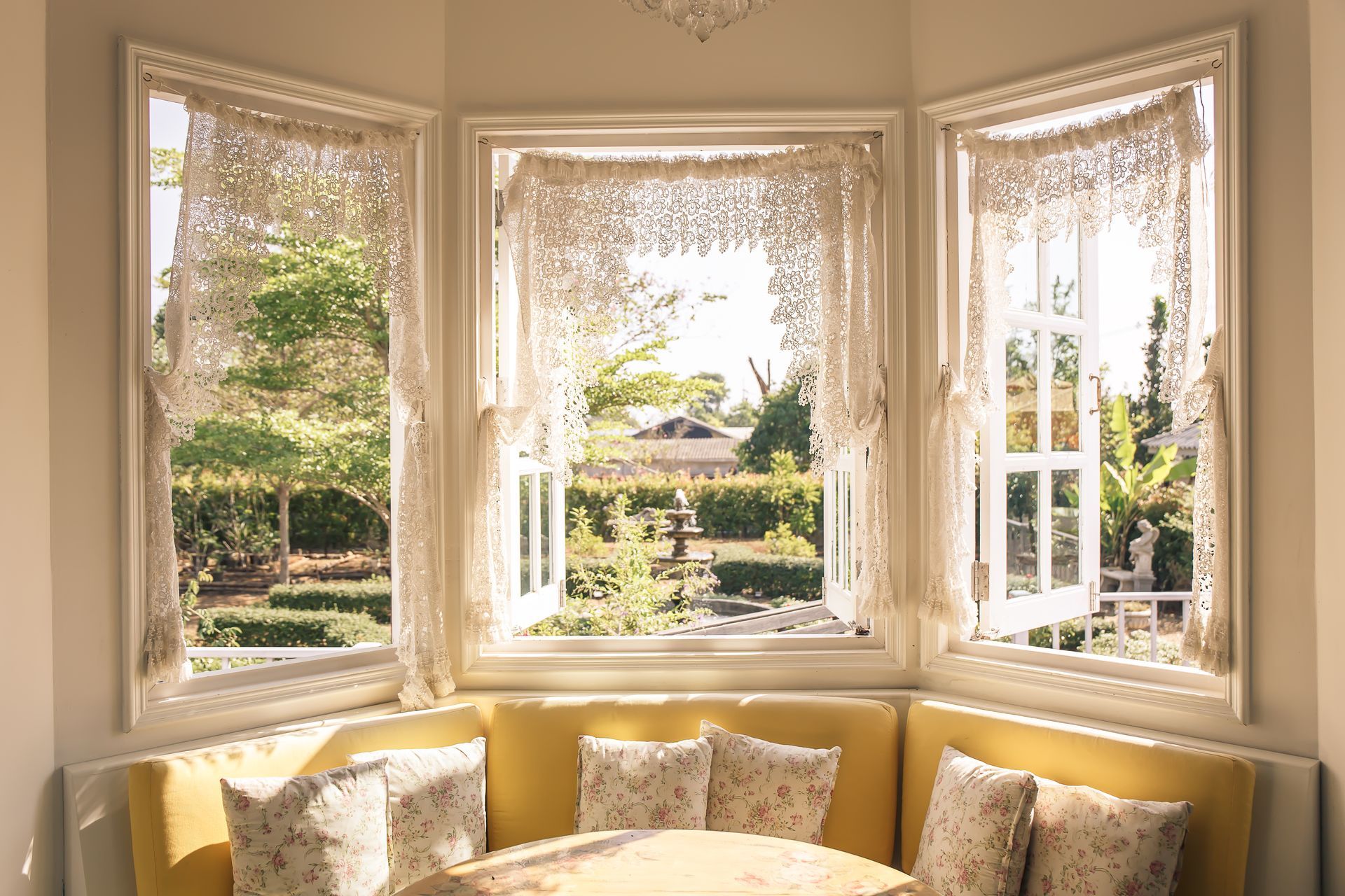 A living room with a couch and a table in front of a bay window.