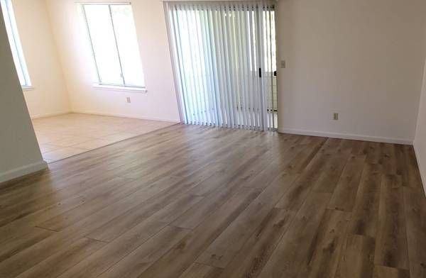 Photo of a large living room showing a dining area with plenty of natural lighting
