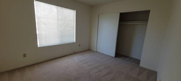 Photo of a bedroom showing a closet with sliding doors