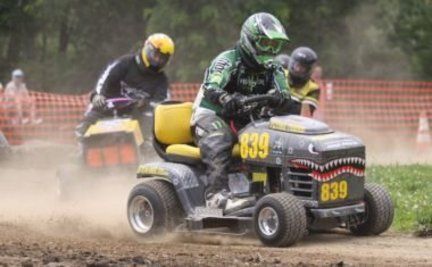 A man is riding a lawn mower with the number 839 on it.