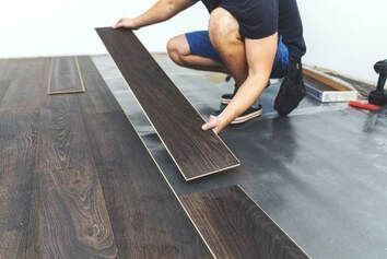 Picture of Handyman Services laying down brown laminate flooring.