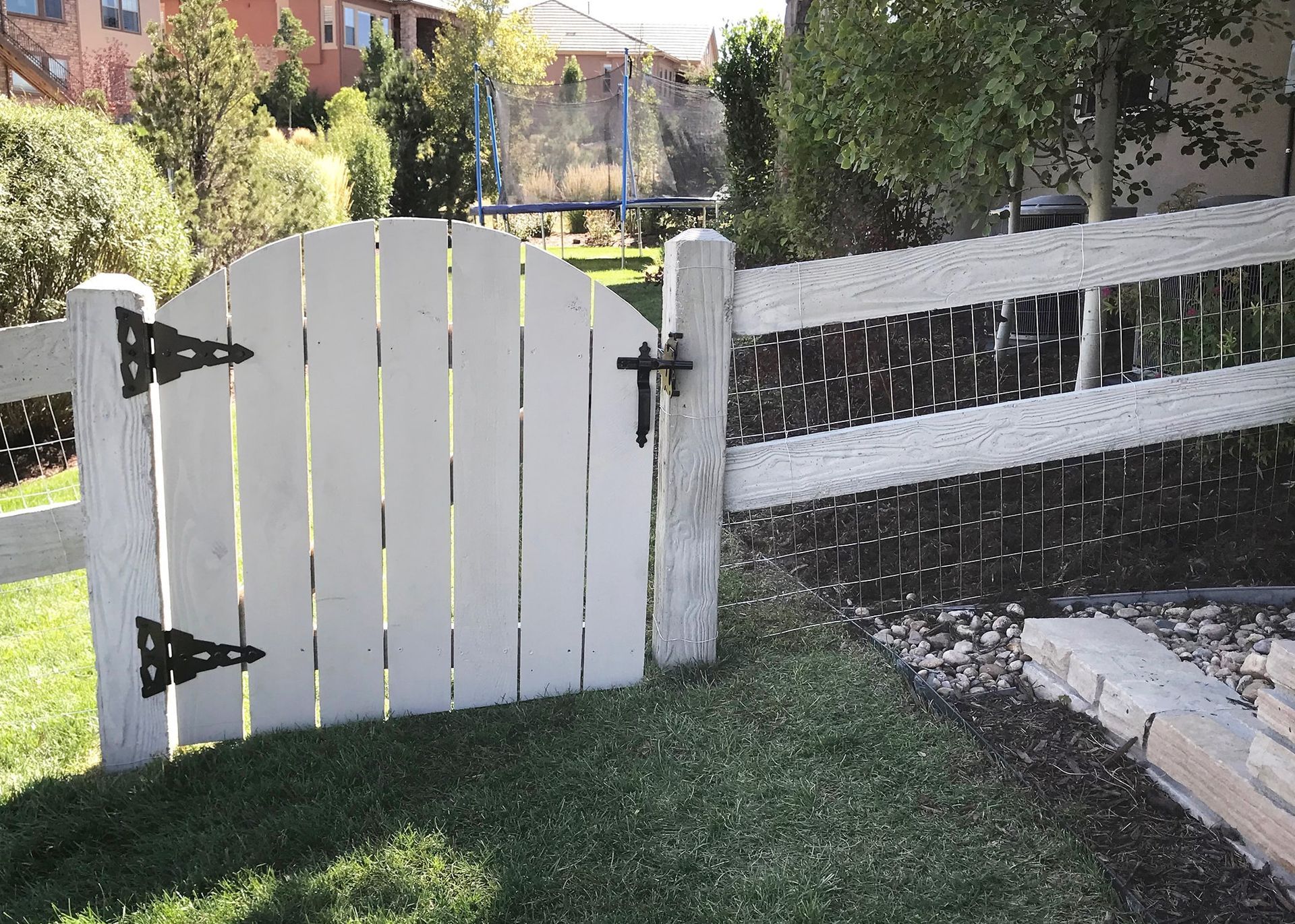 A white picket fence with a gate that is open
