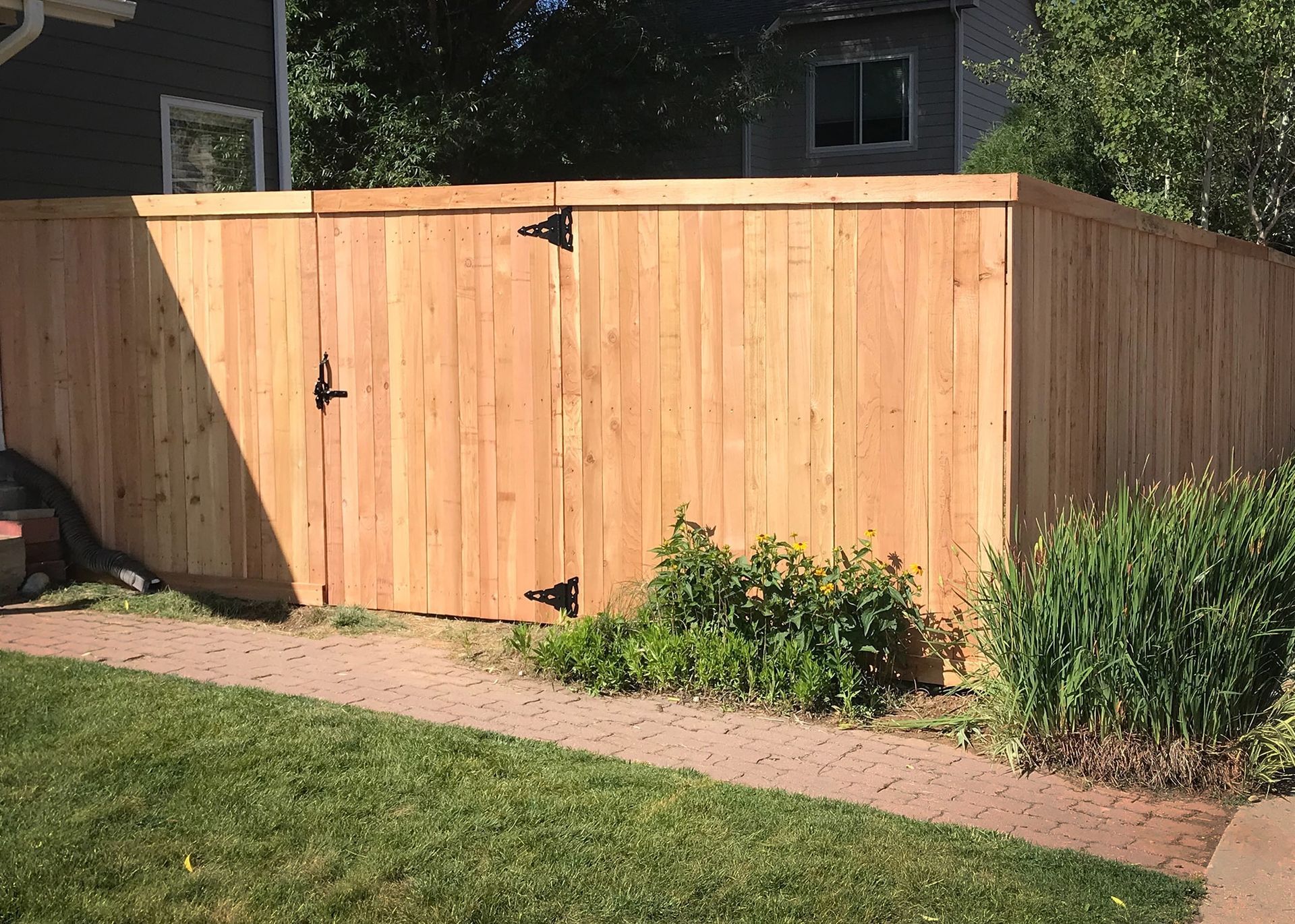 A wooden fence with a gate in the backyard of a house.