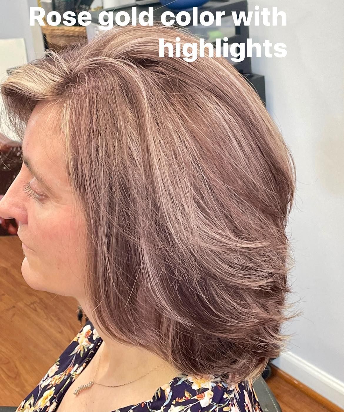 Woman with layered, rose gold hair, with highlights. Indoors.