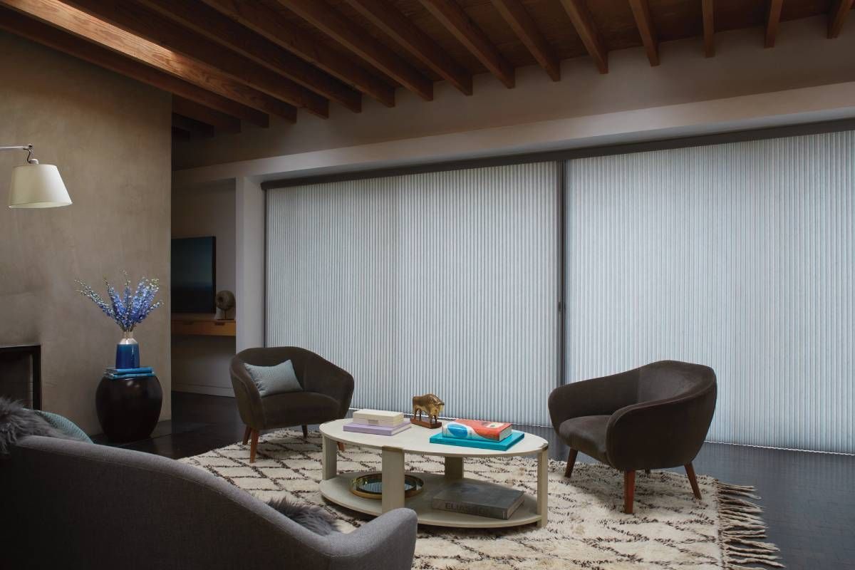 Large sliding glass doors in a simple living room outfitted with Hunter Douglas Duette® Cellular Shades near Huntington, WV