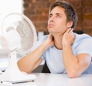 Man using an electric fan — Heating and Air Services in Amherst, NH