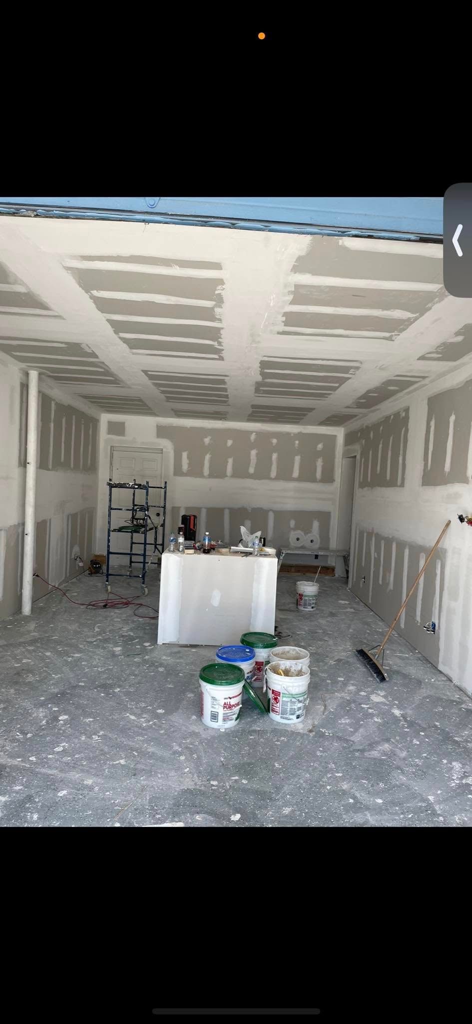 Interior room under construction, with drywall, tools, and materials.