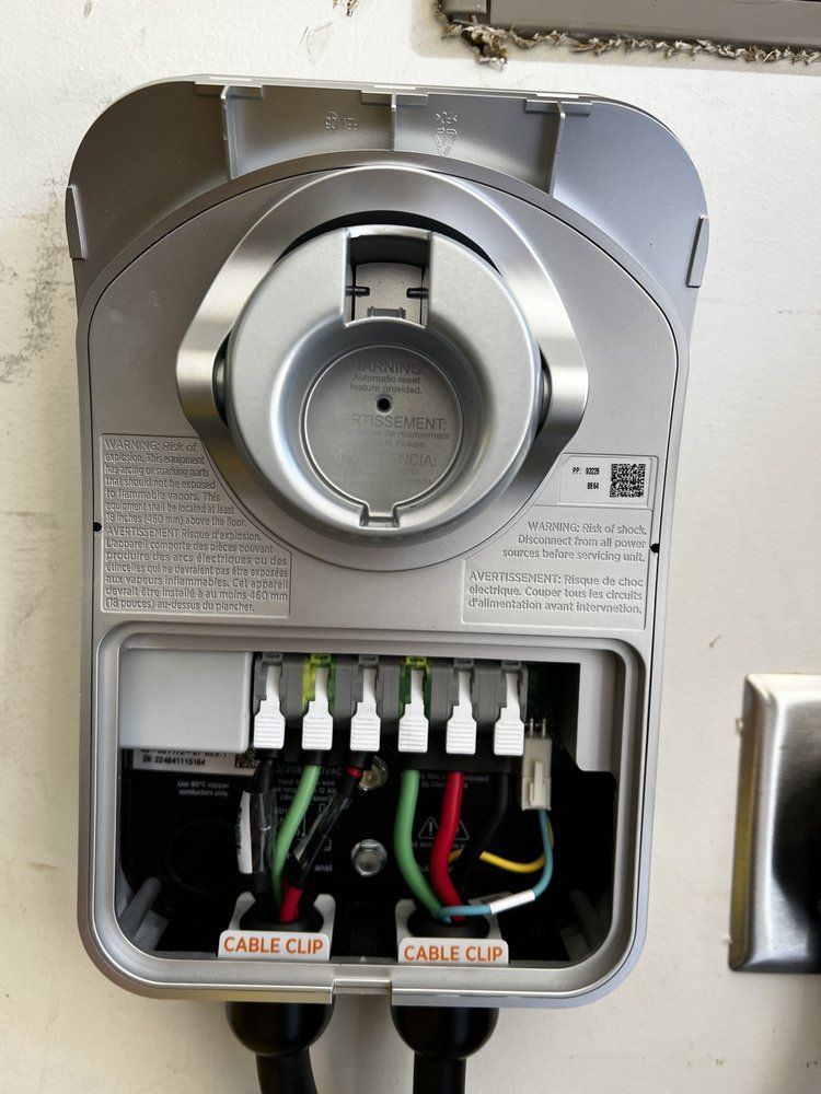 Open electrical meter panel with exposed wiring and circuit breakers on a wall