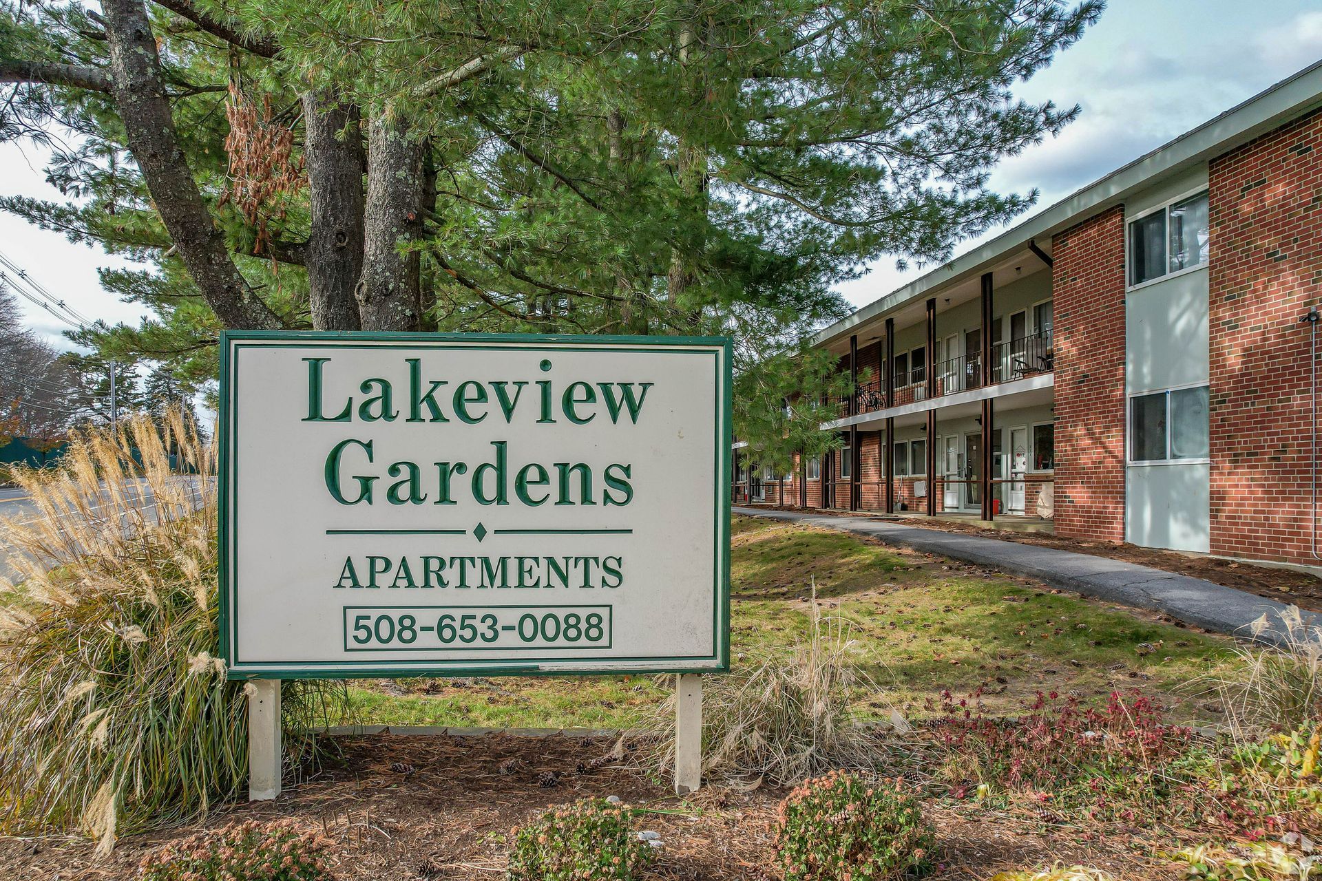 Sign for Lakeview Gardens Apartments with a brick apartment building in the background.