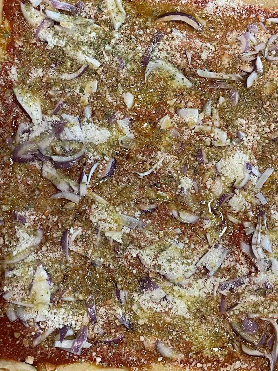 A close up of a pizza with onions and cheese on it.
