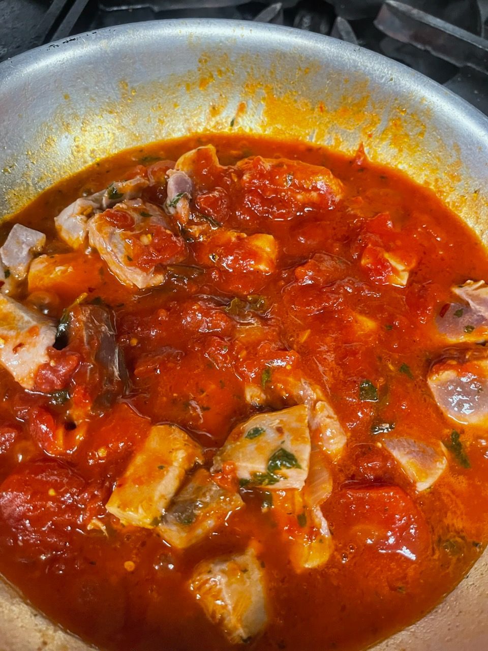 A close up of a pan filled with tomato sauce and meat.