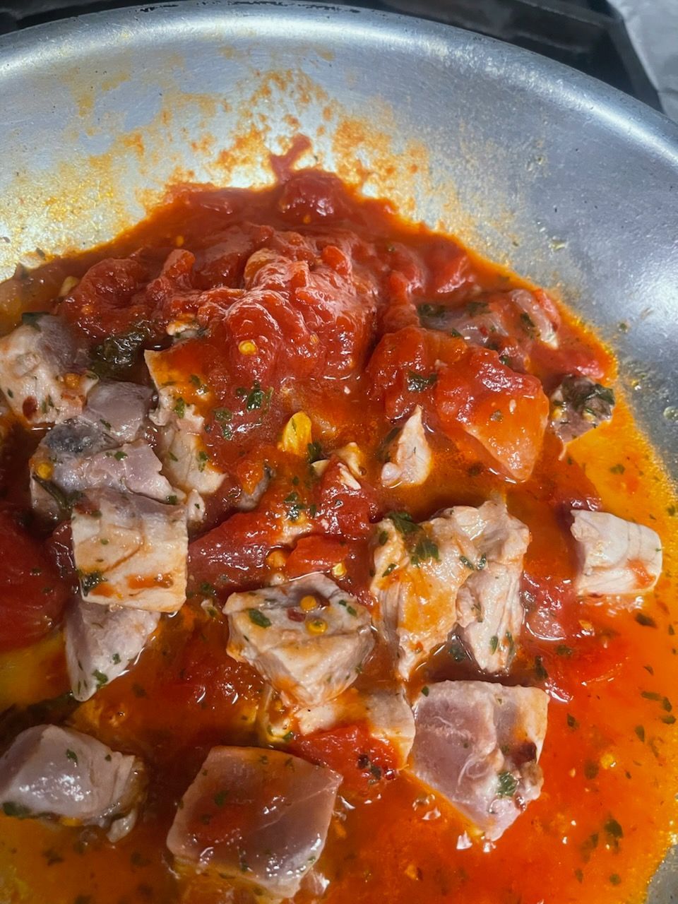 A close up of a pan filled with meat and tomato sauce.