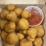 A box filled with fried mushrooms and ketchup.