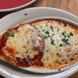 A close up of a pizza on a plate on a table.