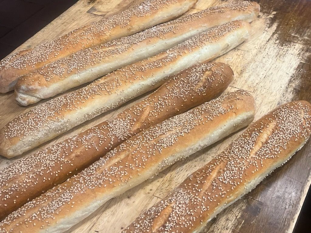 A bunch of bread sticks with sesame seeds on them
