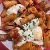 A close up of a plate of pasta with sauce and cheese.