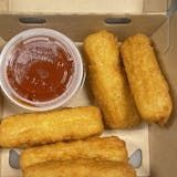 A box of mozzarella sticks and a bowl of ketchup.