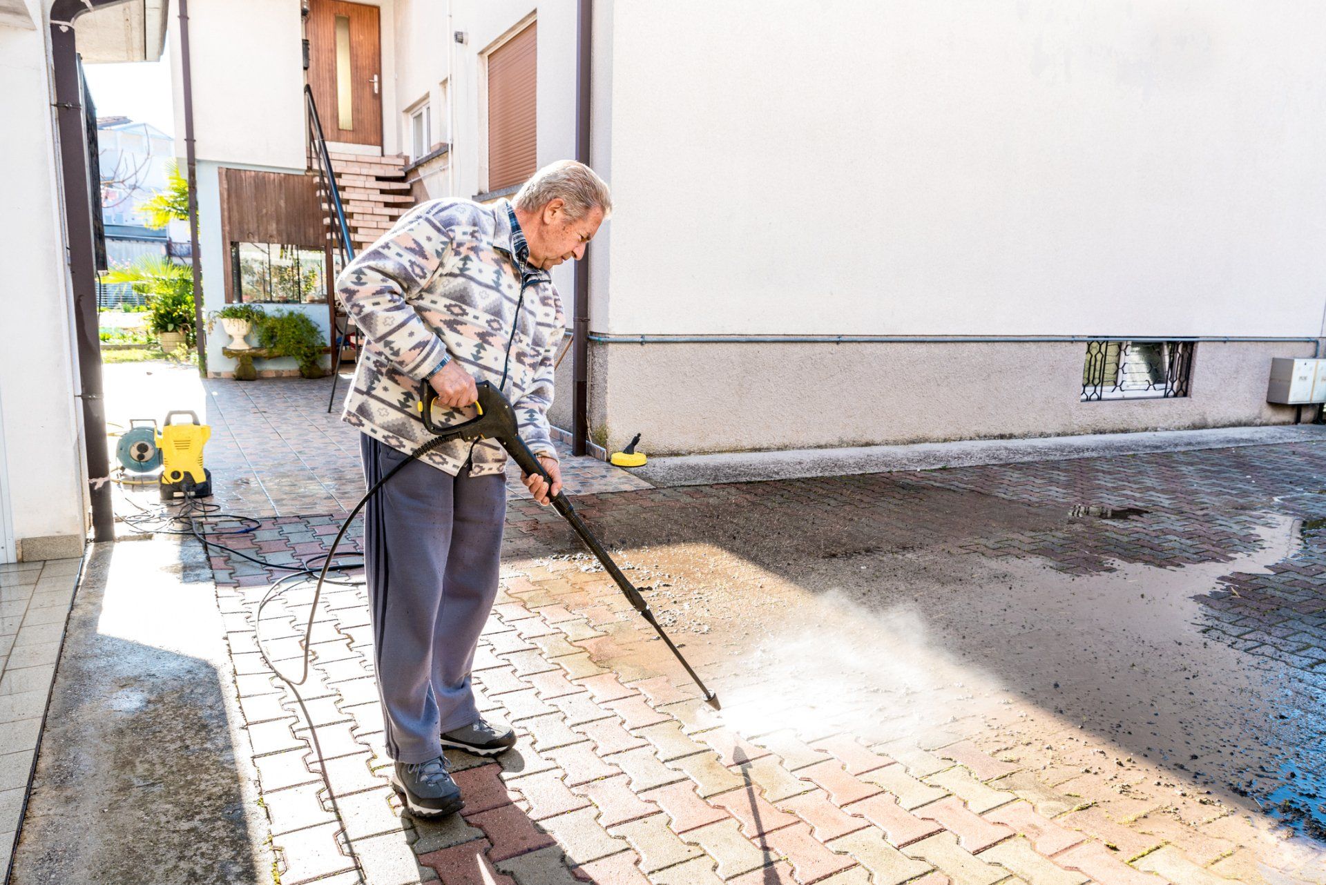 Senior Man Cleaning the Back Yard with High-Pressure Washer — Garfield, GA — Southeast Soft Wash Solutions