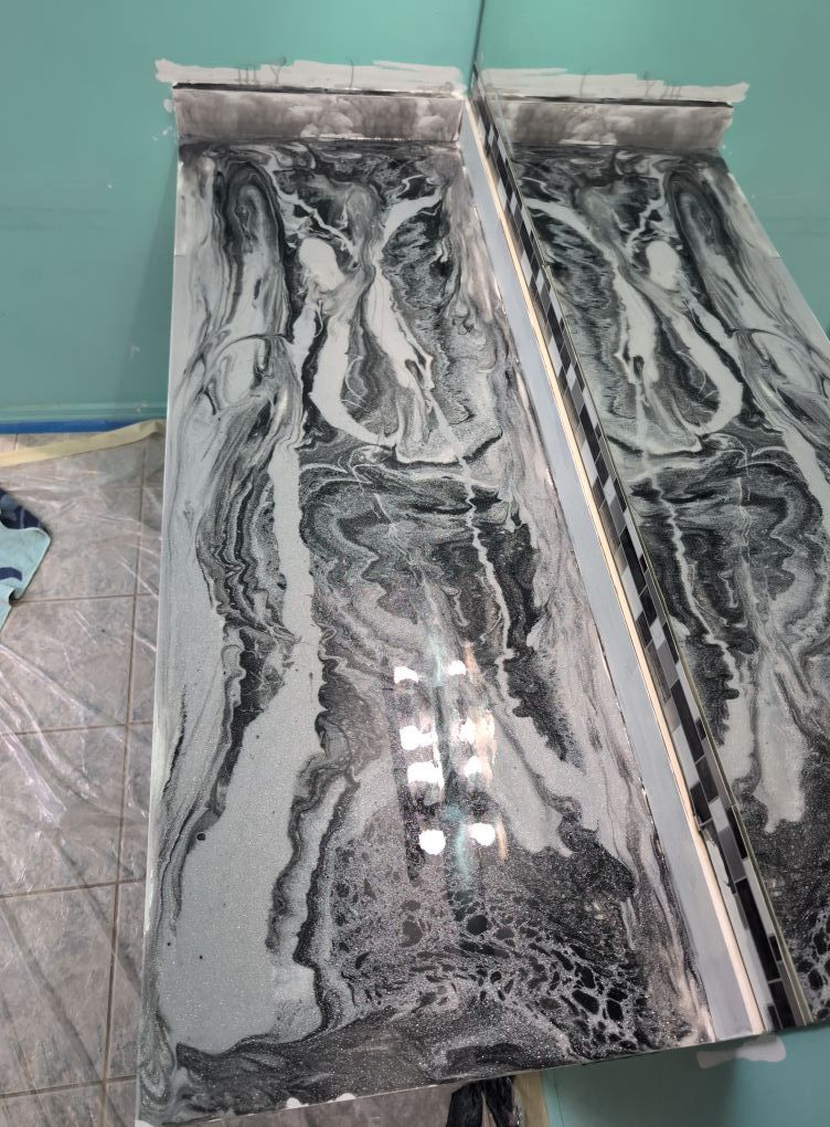 Two rectangular surfaces with a black, white, and gray marbled pattern.