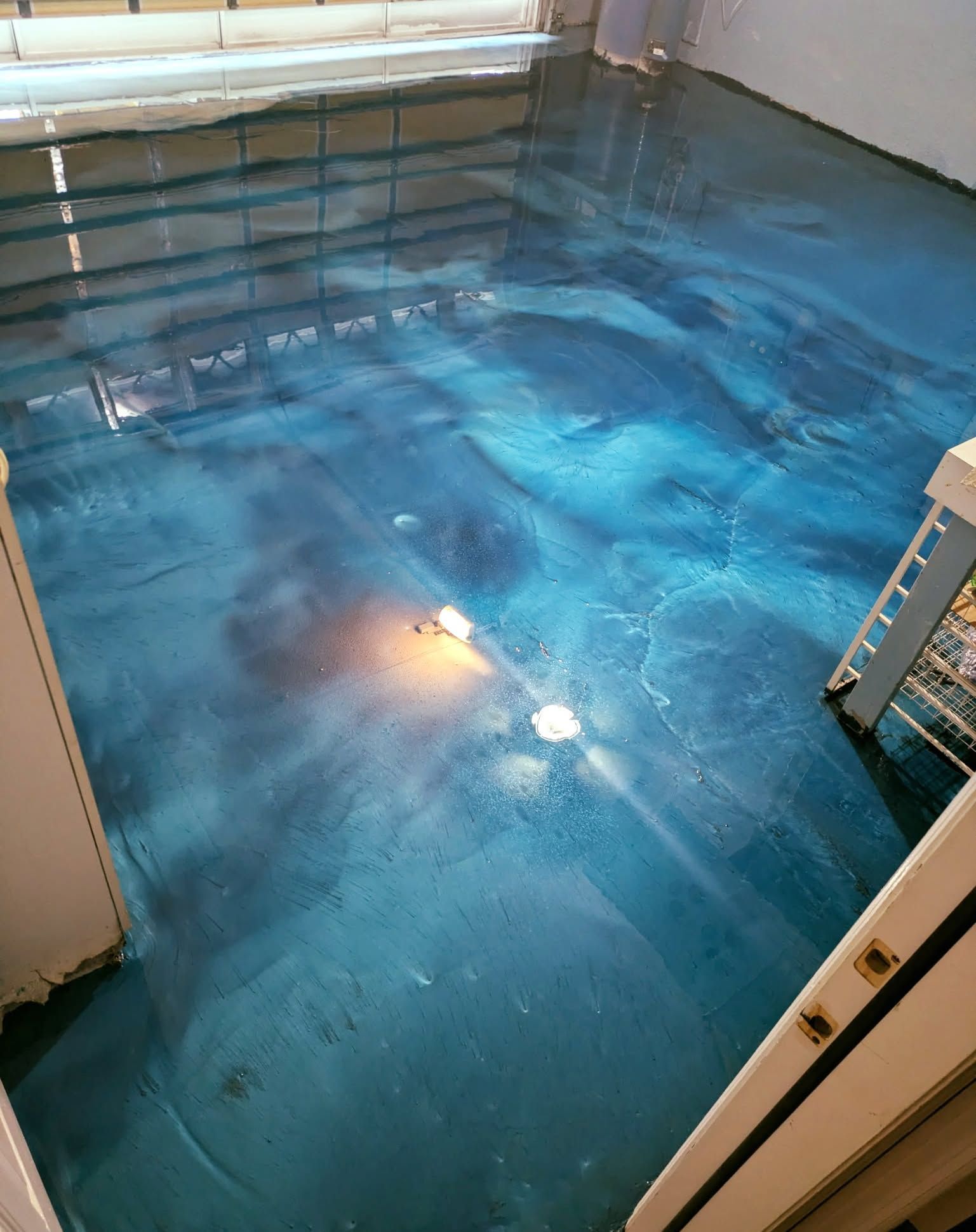 Blue epoxy floor with swirling patterns in a room.