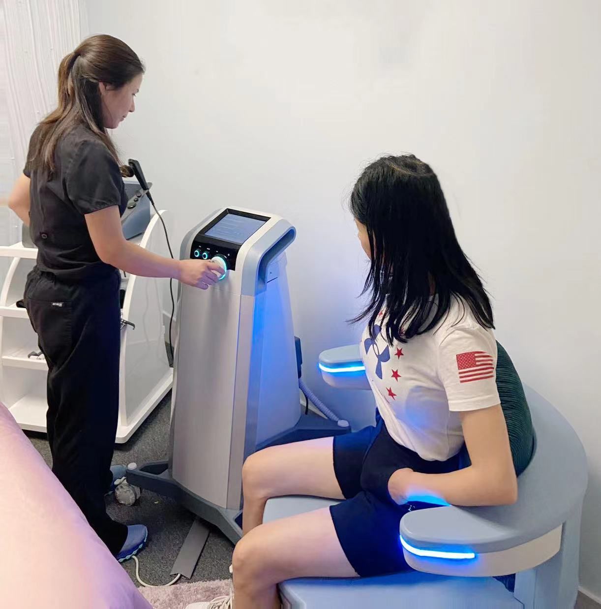 A woman is sitting in a chair while another woman stands behind her.