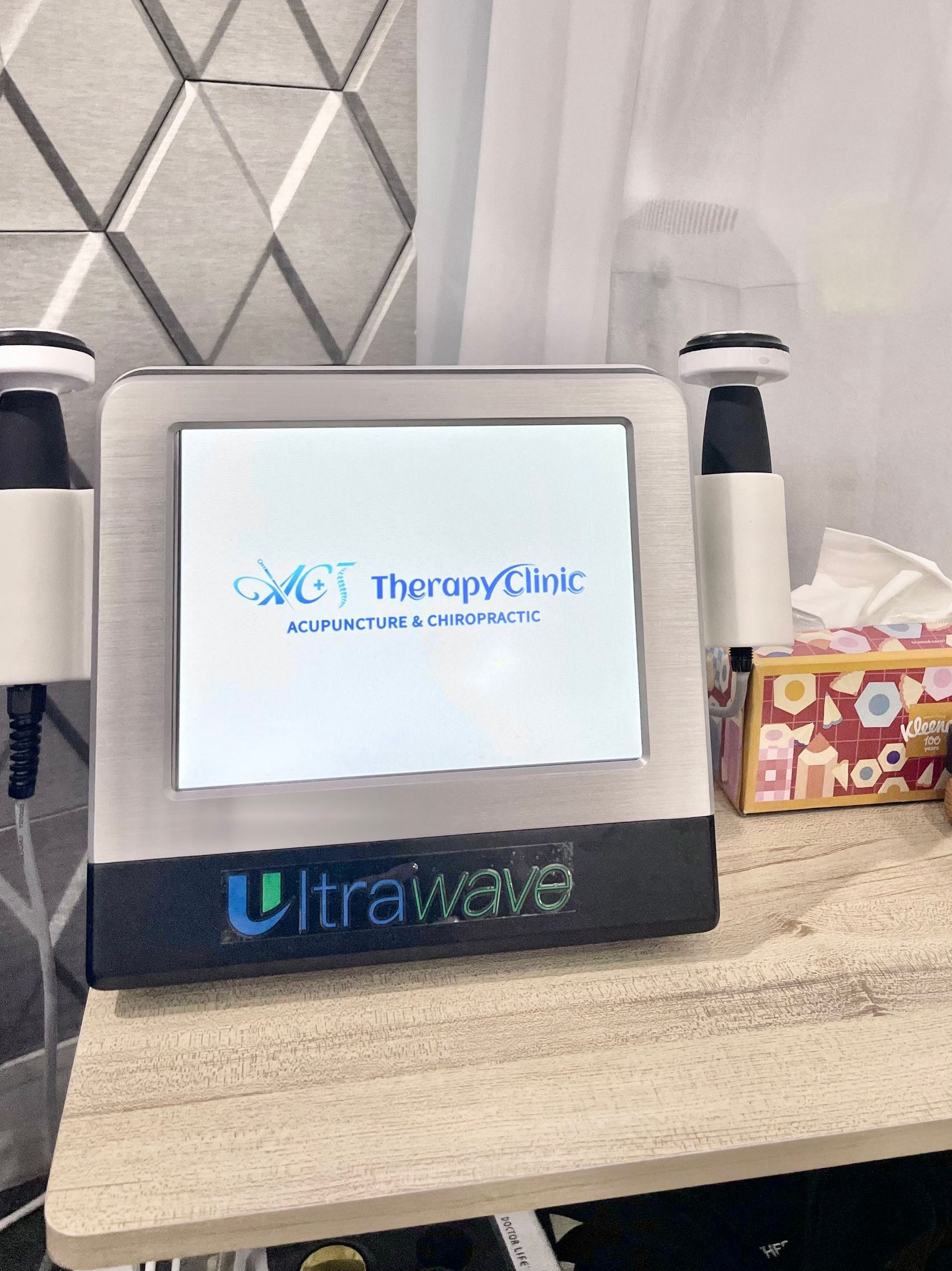 An ultrawave machine is sitting on top of a wooden table.