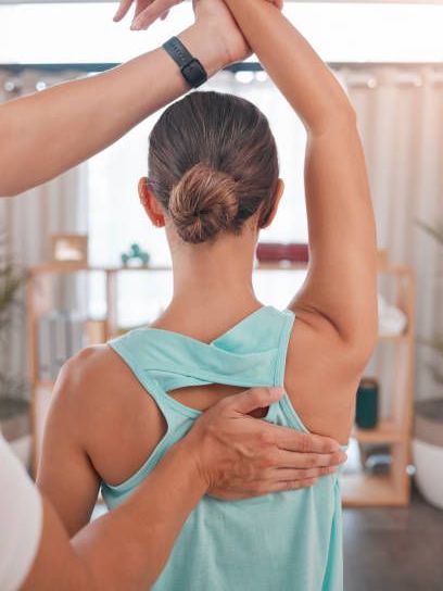 A woman is getting her back examined by a doctor.