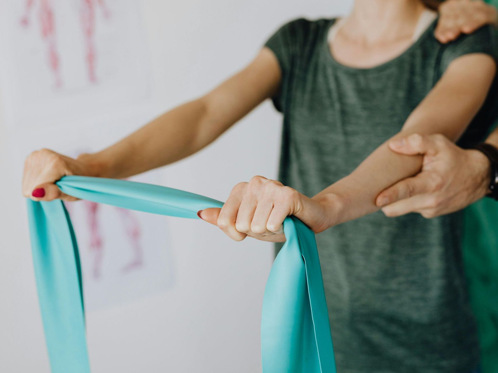 A man in a blue scrub is giving a woman a massage