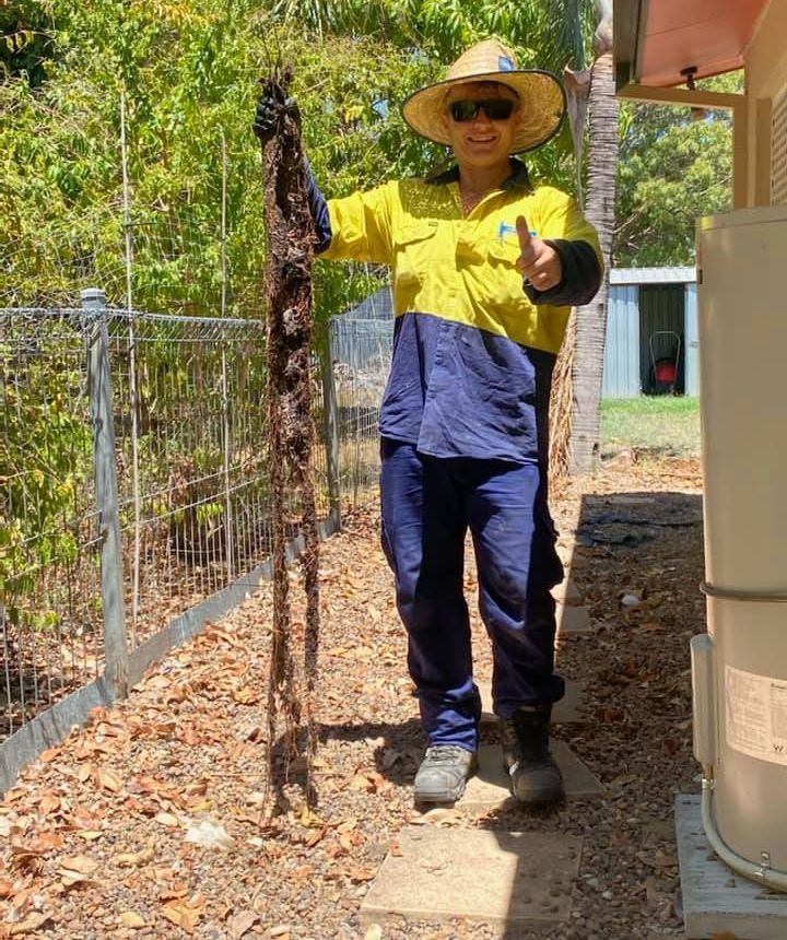 A Man Is Holding A Large Piece Of Wood And Giving A Thumbs Up — Northern Plumbing In Mount Louisa, QLD