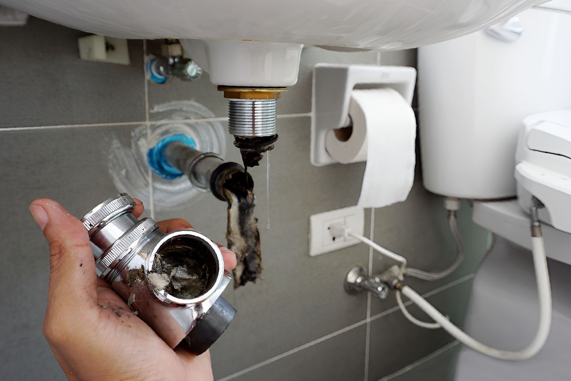 Hand Holding a Dirty Sink Trap — Northern Plumbing In Douglas, QLD