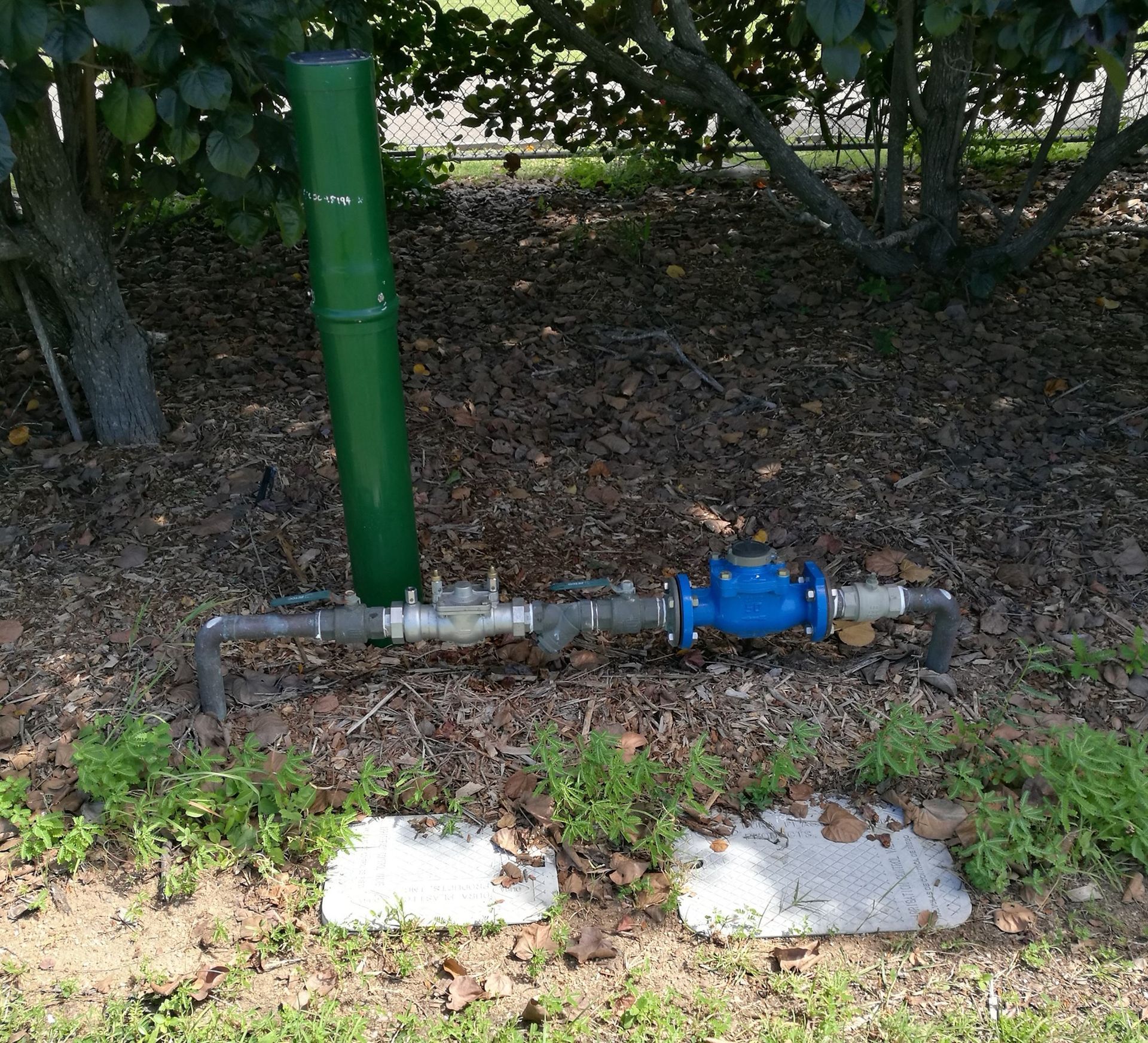 Water Meter With Blue Dial and Green Pipe — Northern Plumbing In Bushland Beach, QLD