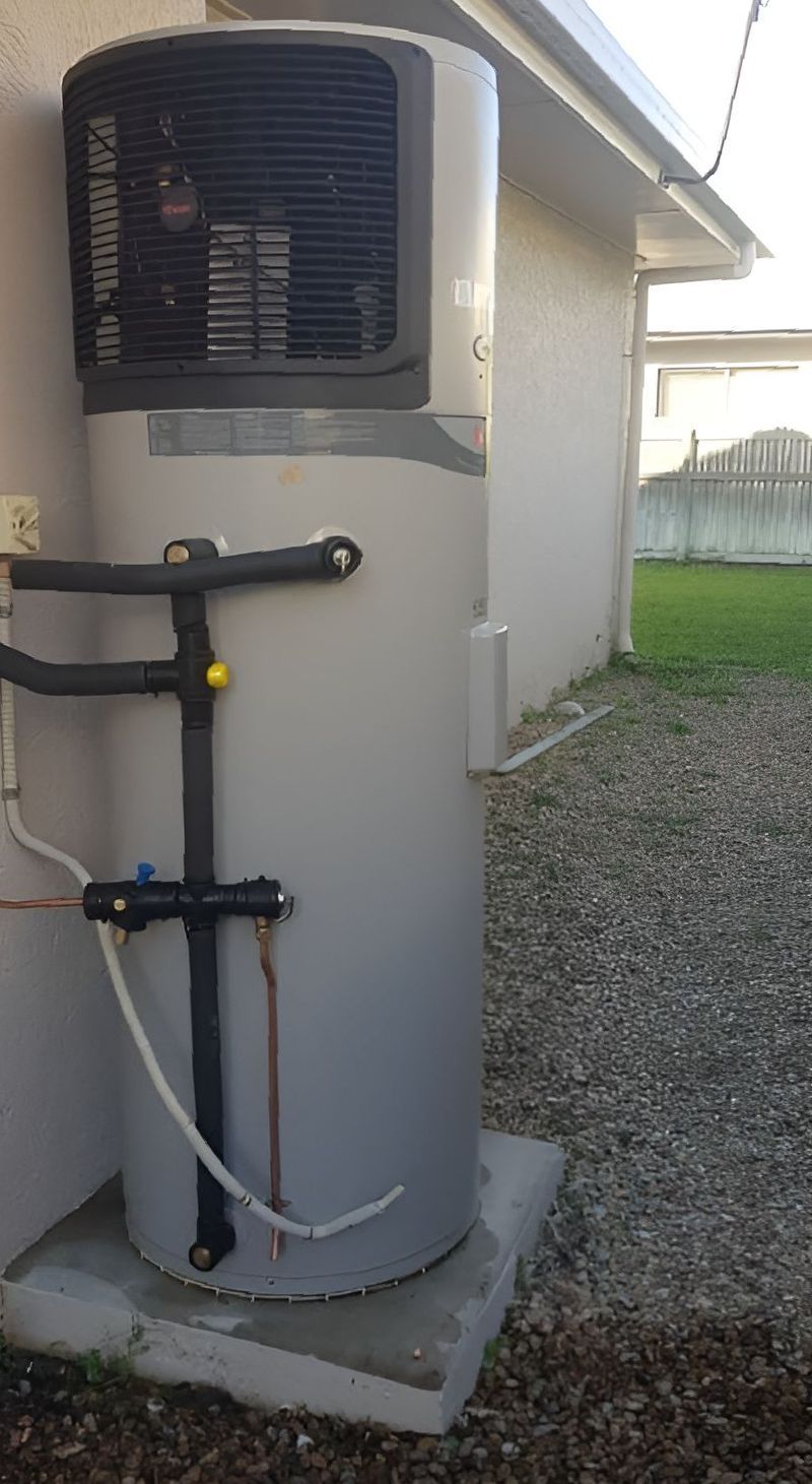 A Large White Water Heater Is Sitting On The Side Of A House — Northern Plumbing In Mount Louisa, QLD