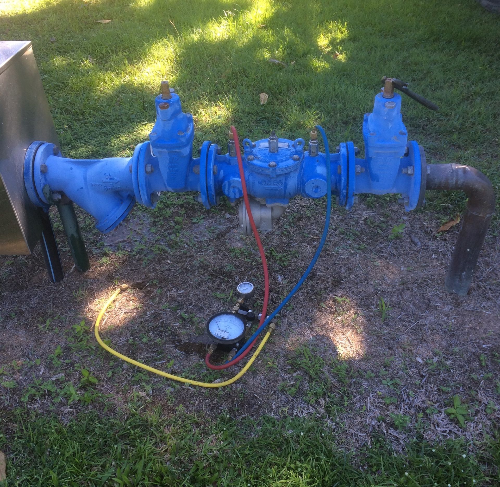 Blue Water Pipes With Gauges in a Grassy Area, Connected to a Metal Box — Northern Plumbing In Burdell, QLD