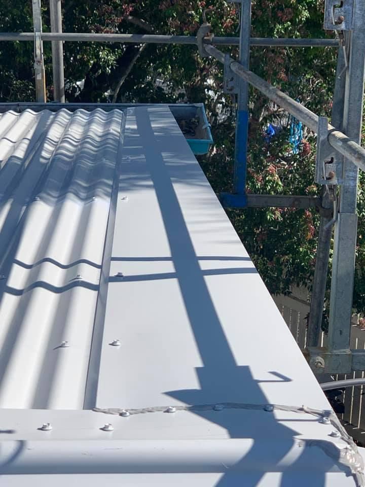 A White Roof With Scaffolding Around It And Trees In The Background — Northern Plumbing In Mount Louisa, QLD