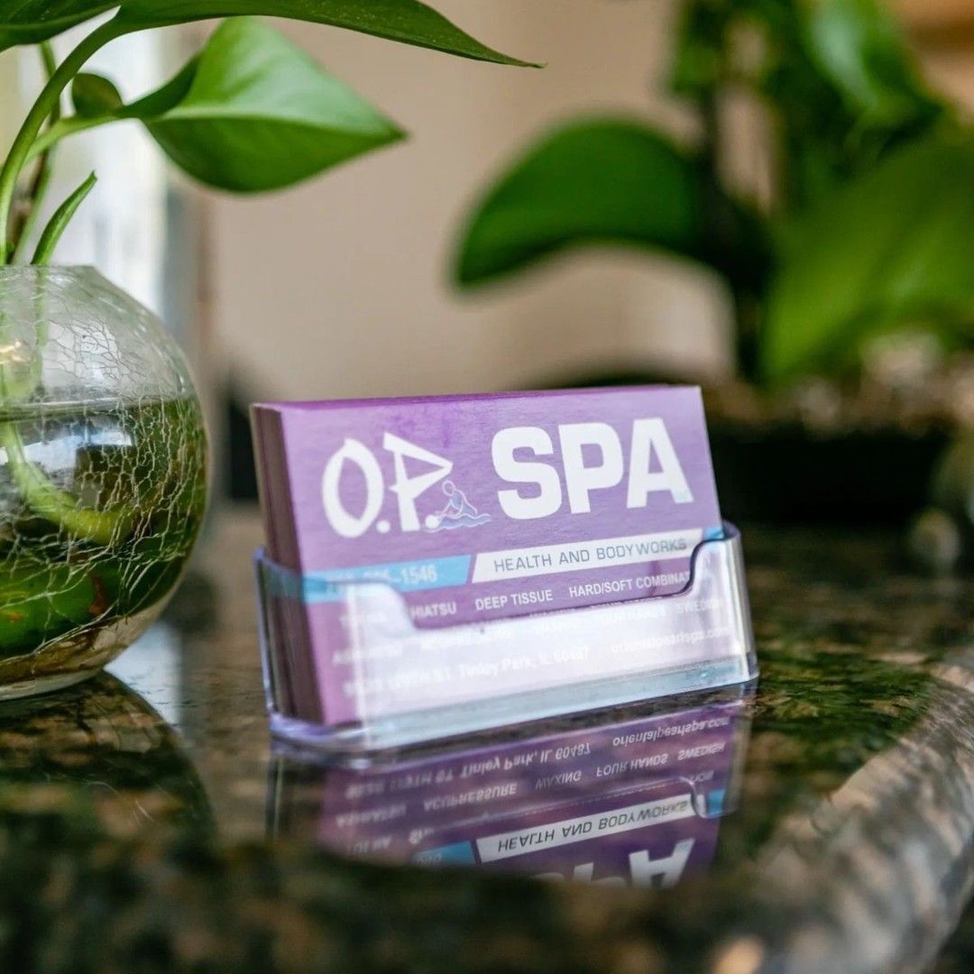 A business card for op spa is sitting on a counter