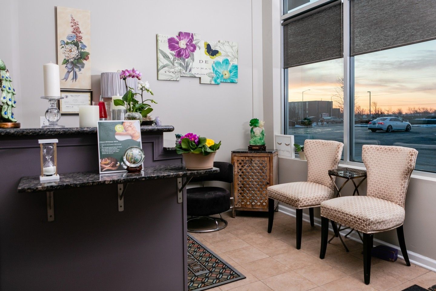 A waiting room with two chairs , a counter and a window.
