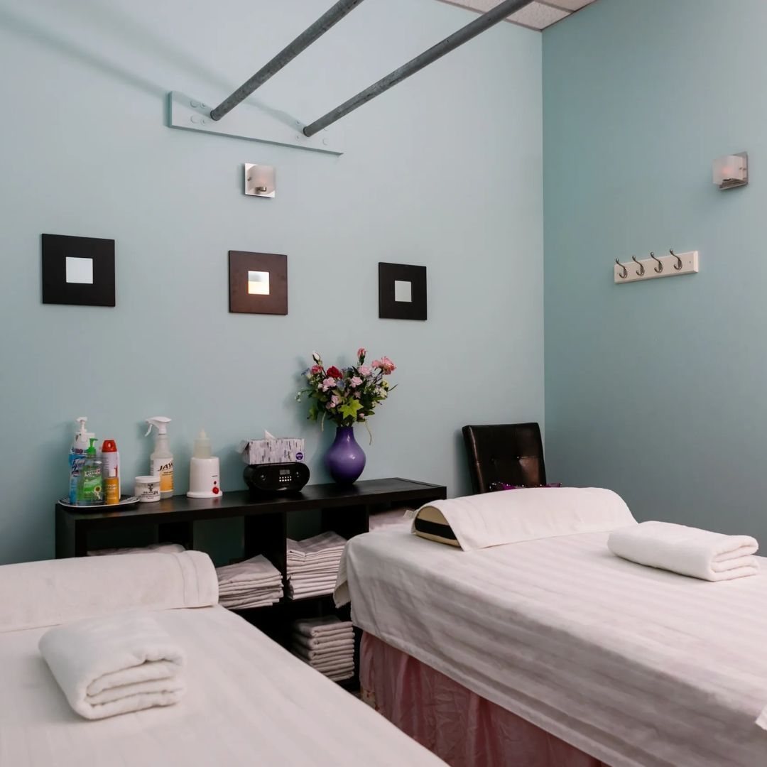 A room with two beds and a vase of flowers