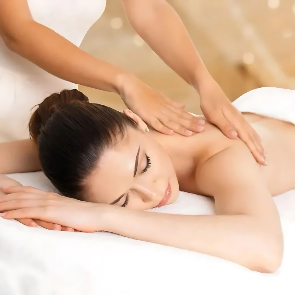 A woman is laying on a bed getting a massage