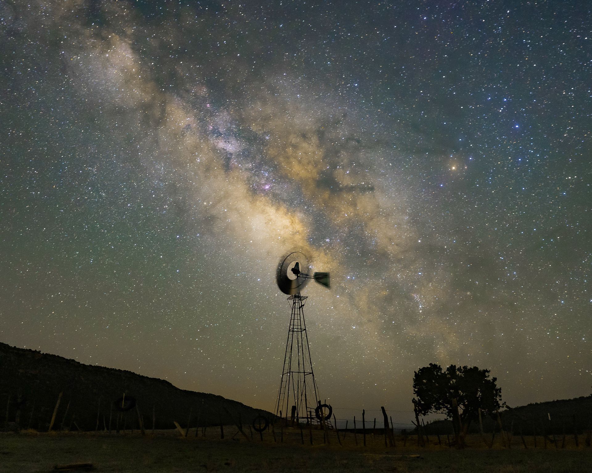 A windmill with a milky way in the background