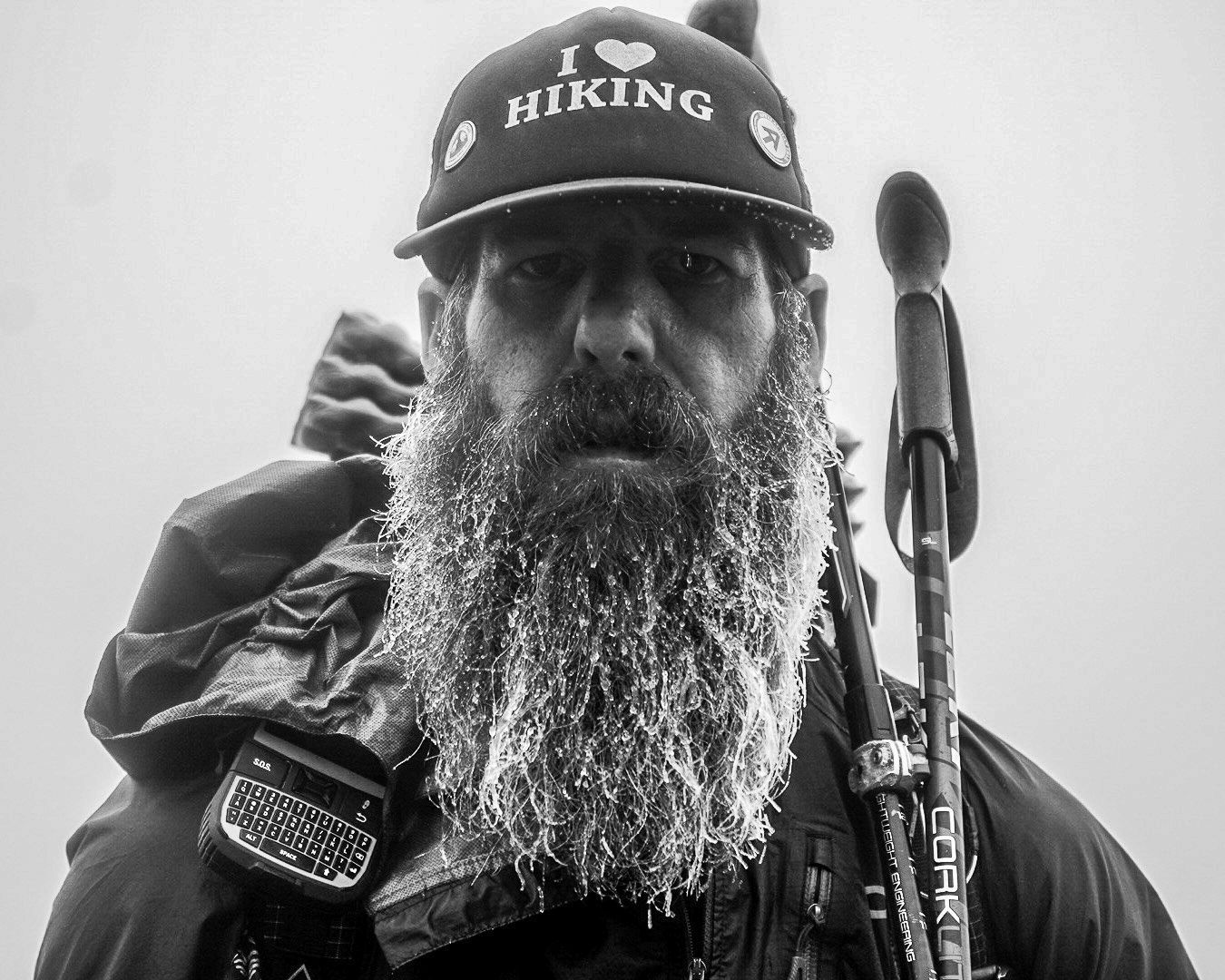 A man with a beard wearing a hat that says i love hiking