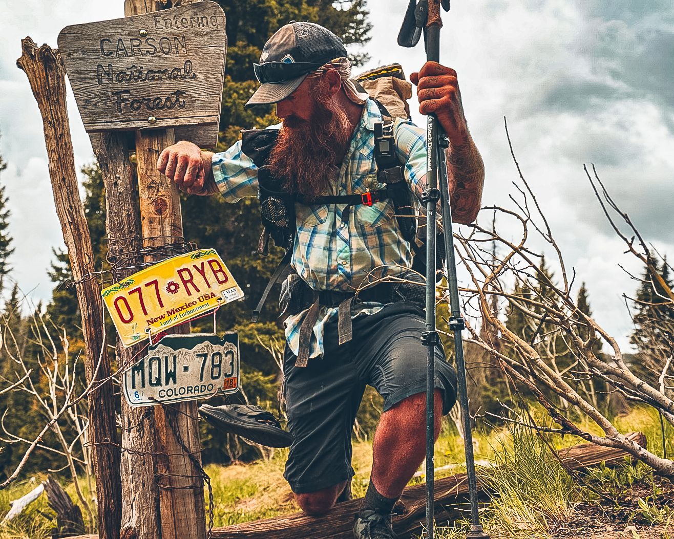 A man is kneeling down next to a sign that says 077 ry8