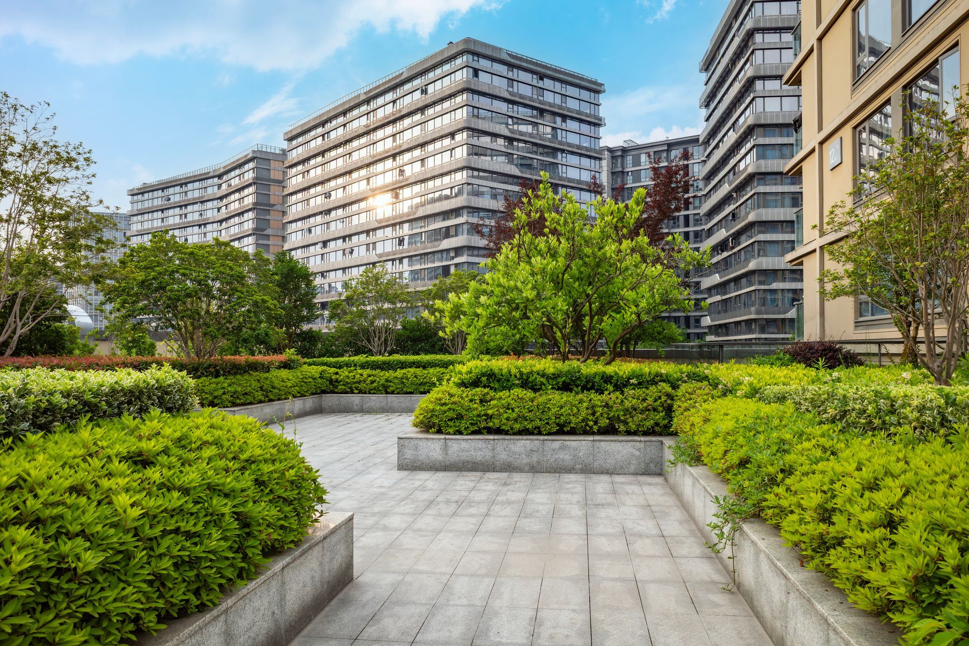 Commercial landscape management with modern office buildings and lush green garden pathways. Commercial landscape management with modern office buildings and lush green garden pathways.