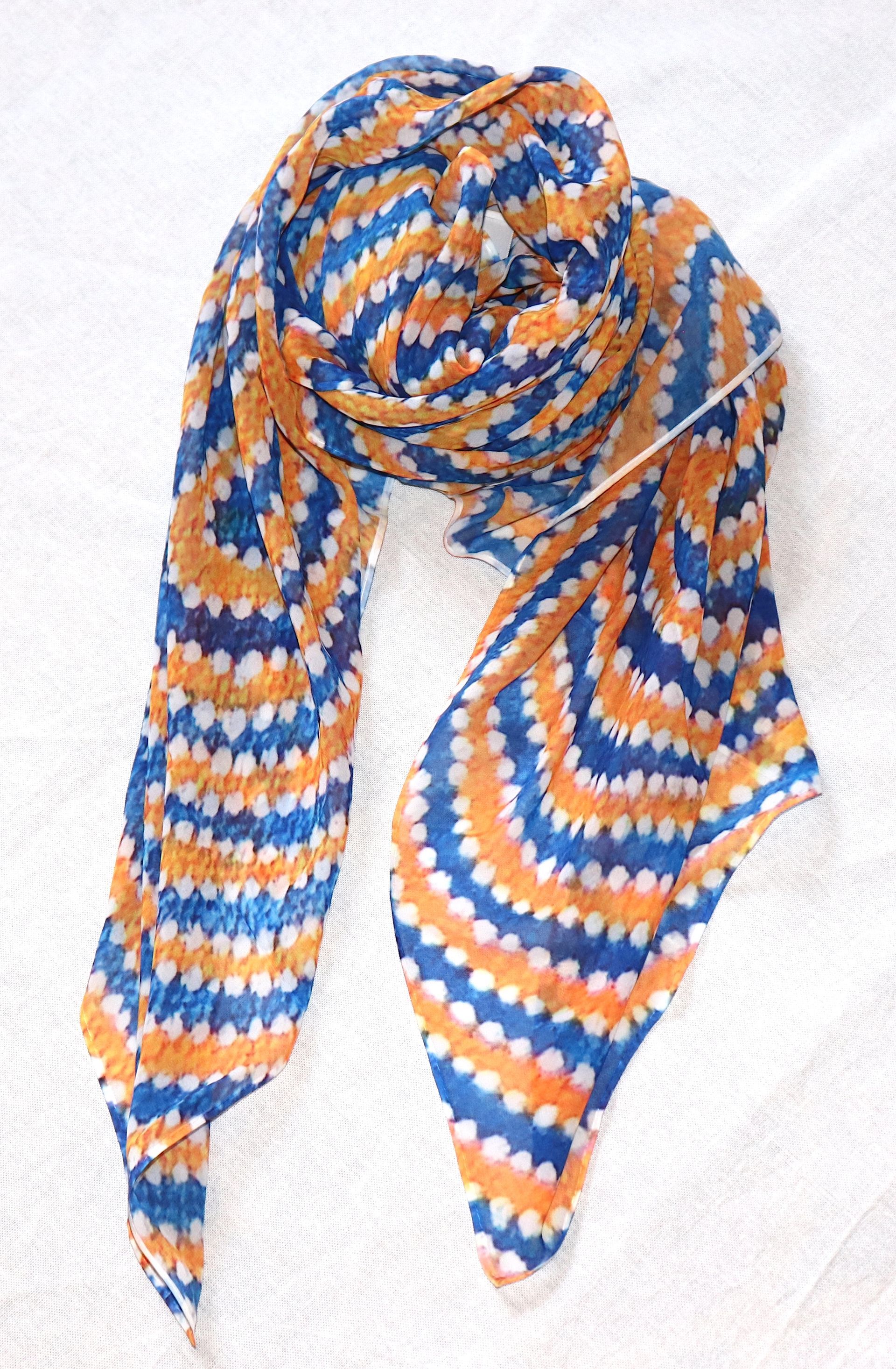 A blue and orange scarf is sitting on a white surface.